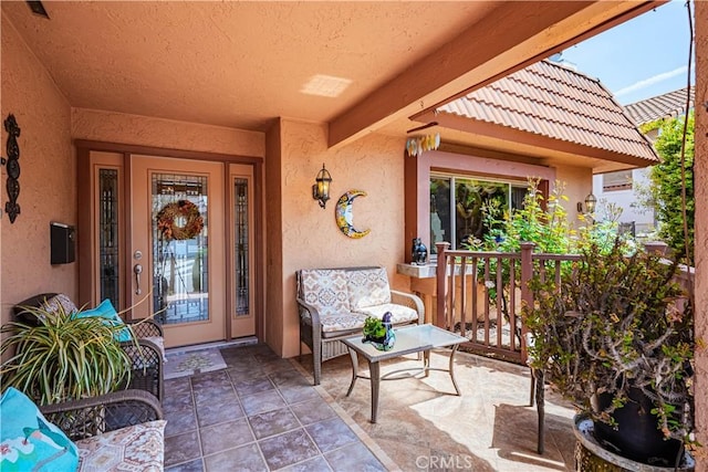 view of exterior entry with stucco siding and a tiled roof