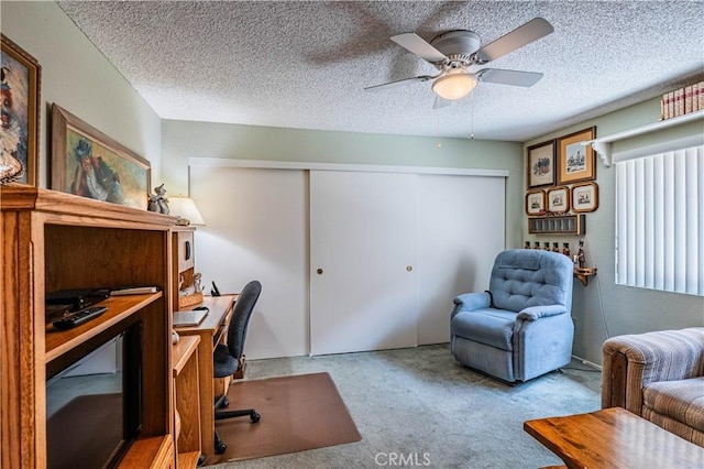 office featuring a textured ceiling, carpet, and ceiling fan