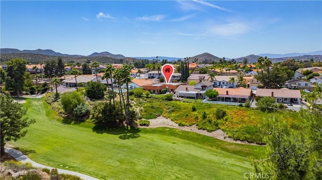 drone / aerial view with a mountain view, golf course view, and a residential view