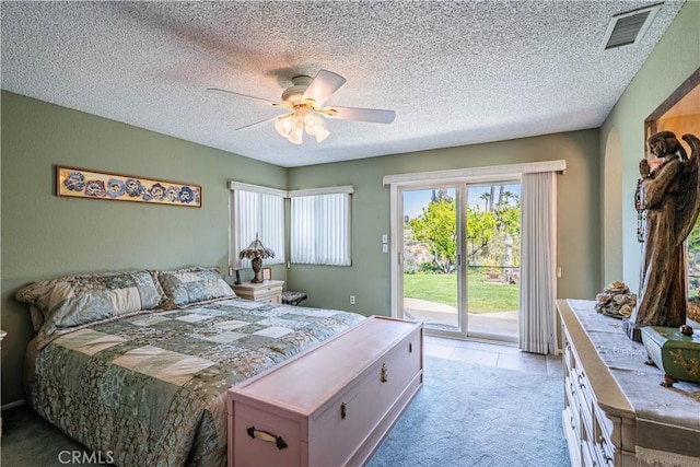 bedroom featuring access to outside, ceiling fan, light carpet, a textured ceiling, and visible vents