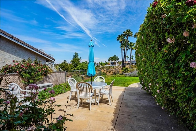 view of patio / terrace with fence, outdoor dining space, and stairs