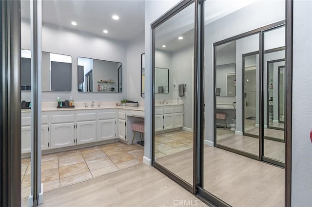 bathroom featuring vanity, recessed lighting, and wood finished floors