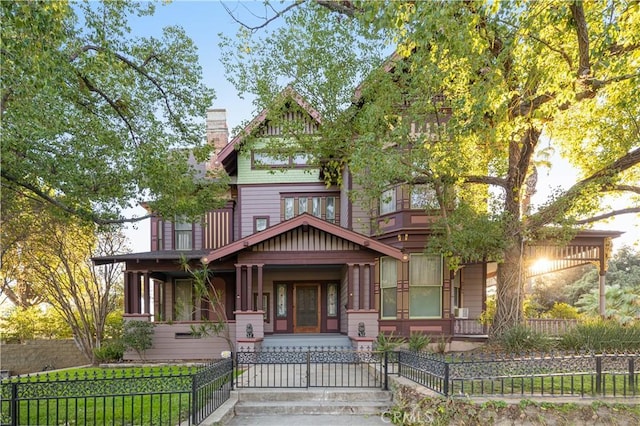4492 12th St, Riverside, CA 92501 - victorian house with a gate, covered porch, a fenced front yard, and a chimney