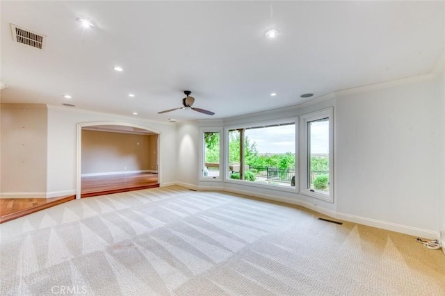 spare room with ceiling fan, light colored carpet, and visible vents