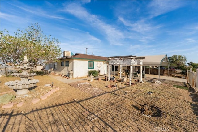 rear view of property featuring a pergola, a fenced backyard, a patio area, and stucco siding