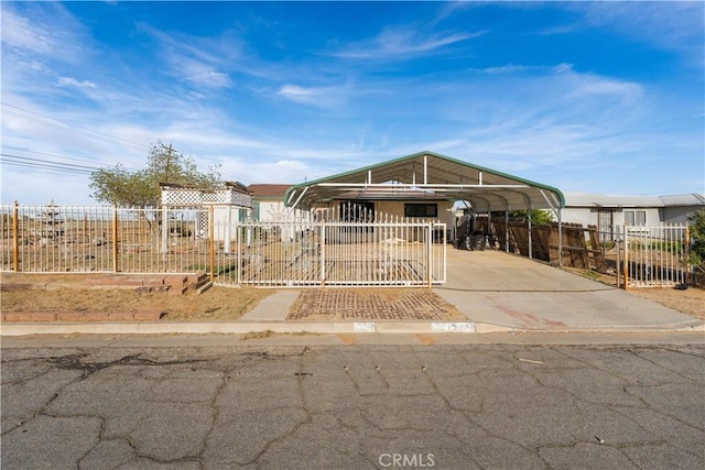 manufactured / mobile home featuring concrete driveway, fence private yard, and a detached carport