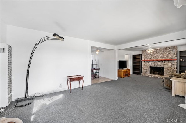 living room featuring a heating unit, a ceiling fan, carpet flooring, and a fireplace