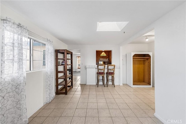 interior space with a skylight and tile patterned flooring