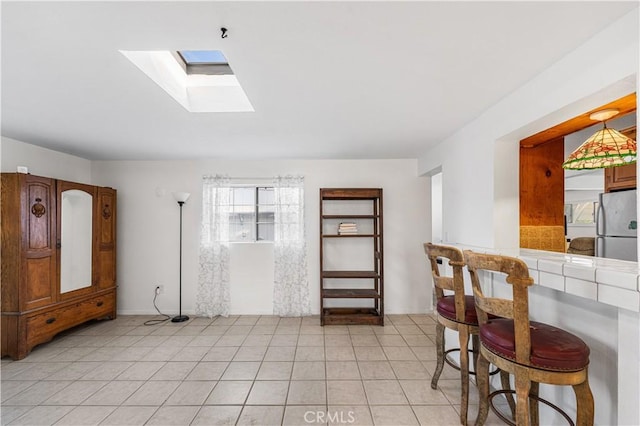 interior space with a skylight and light tile patterned floors