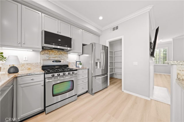 15212 Cambridge St, Tustin, CA 92782 - kitchen with crown molding, appliances with stainless steel finishes, light wood finished floors, and visible vents