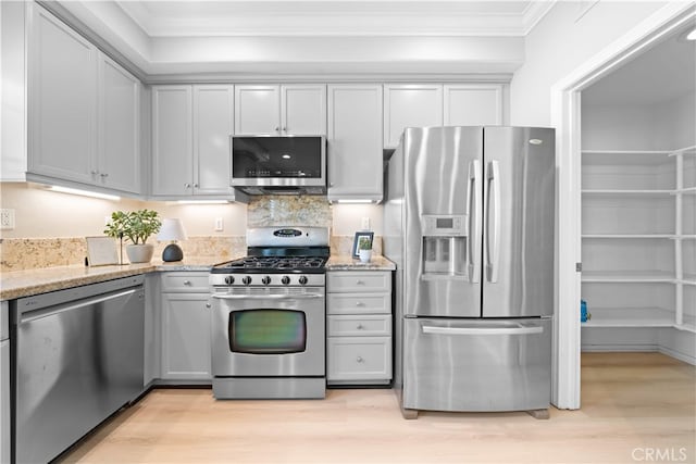 15212 Cambridge St, Tustin, CA 92782 - kitchen with light wood-style floors, appliances with stainless steel finishes, ornamental molding, and light stone countertops