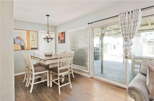 15709 Devonshire St, Granada Hills, CA 91344 - dining space with a chandelier, healthy amount of natural light, wood finished floors, and baseboards