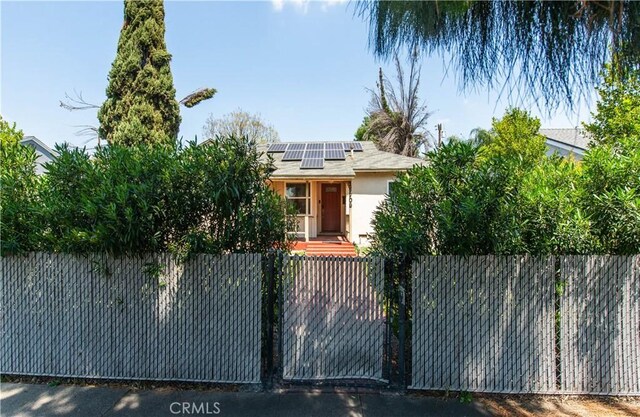 15709 Devonshire St, Granada Hills, CA 91344 - view of front of home with a fenced front yard, solar panels, and stucco siding
