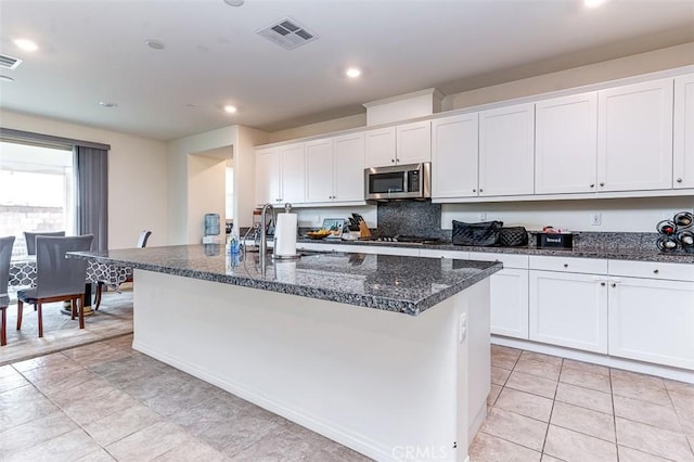 5597 Royal Oaks Way, Fontana, CA 92336 - kitchen with stainless steel microwave, a sink, white cabinetry, a center island with sink, and recessed lighting