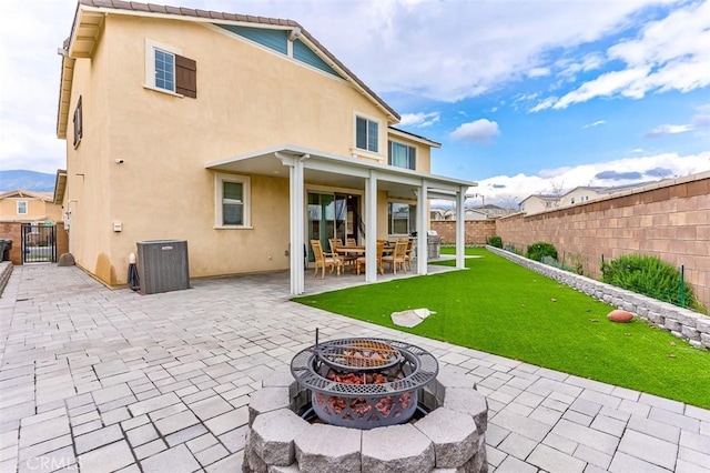 5597 Royal Oaks Way, Fontana, CA 92336 - back of house featuring stucco siding, a fire pit, a patio, and a gate