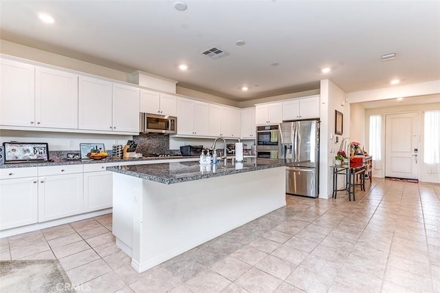 5597 Royal Oaks Way, Fontana, CA 92336 - kitchen with appliances with stainless steel finishes, an island with sink, light tile patterned flooring, white cabinetry, and recessed lighting