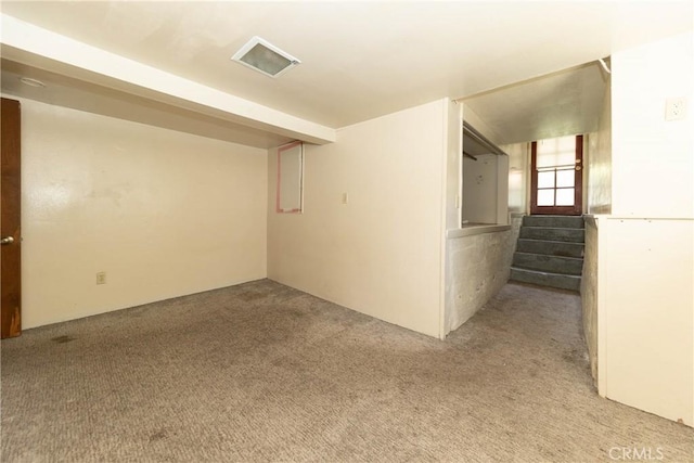 empty room featuring light colored carpet and stairway
