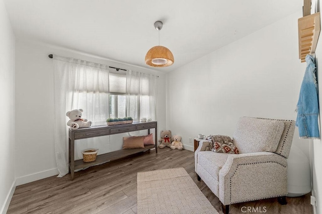 sitting room with baseboards and wood finished floors