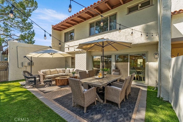 view of patio with an outdoor living space with a fire pit and fence
