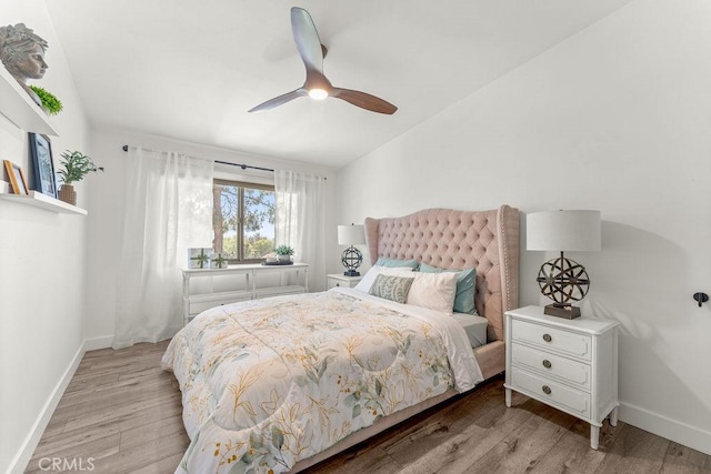 bedroom featuring baseboards, a ceiling fan, light wood-style flooring, and lofted ceiling