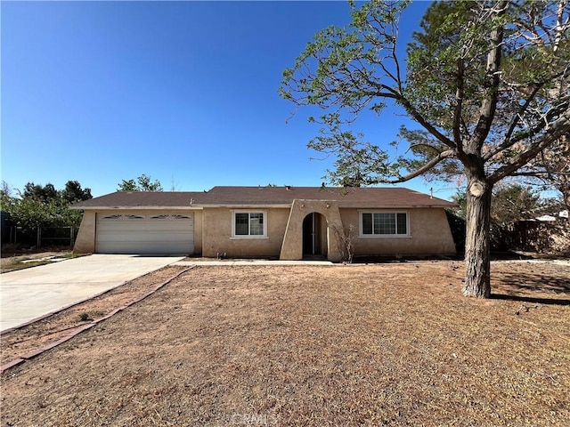 ranch-style home with an attached garage, stucco siding, and concrete driveway