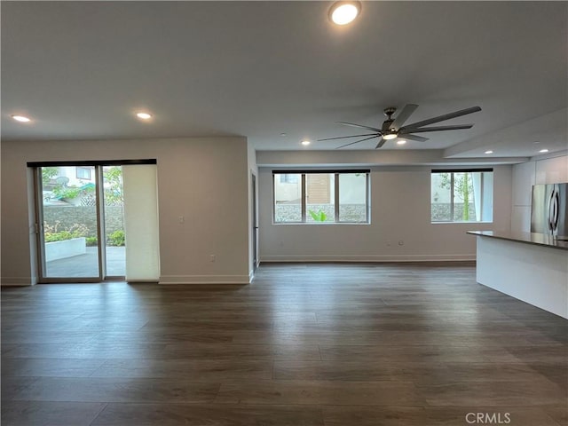 unfurnished living room with dark wood finished floors, baseboards, ceiling fan, and recessed lighting