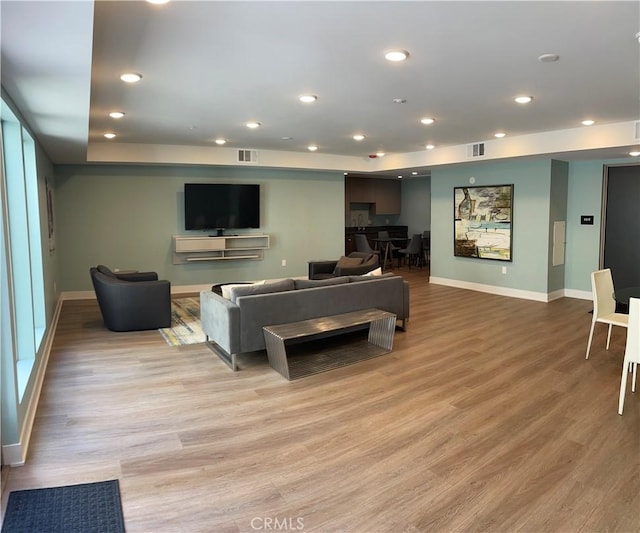 living area with baseboards, recessed lighting, visible vents, and light wood-type flooring