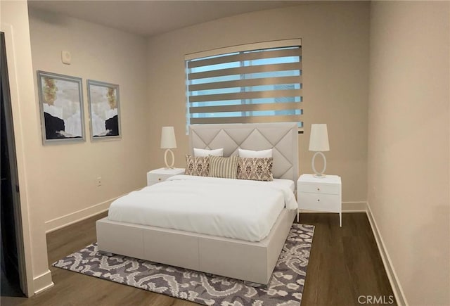 bedroom with baseboards and wood finished floors