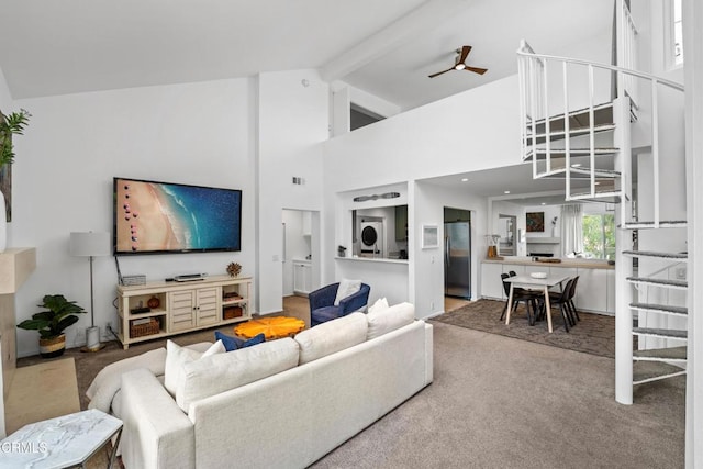 carpeted living room featuring a ceiling fan, high vaulted ceiling, and beam ceiling