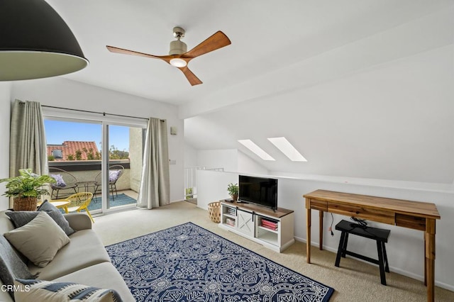 living room featuring carpet flooring, lofted ceiling with skylight, and ceiling fan