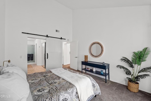 bedroom featuring visible vents, light carpet, baseboards, high vaulted ceiling, and a barn door