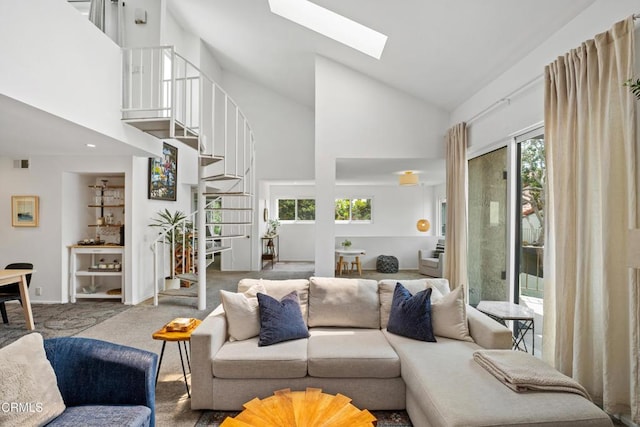 living area featuring high vaulted ceiling, carpet, stairs, a skylight, and visible vents