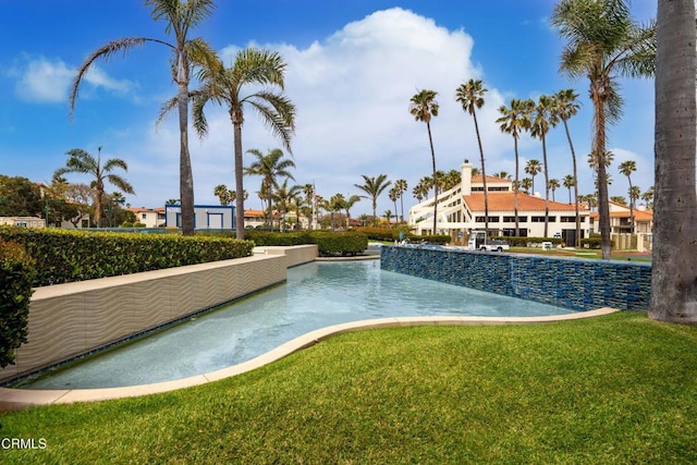 view of pool featuring a lawn