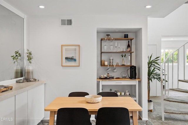 carpeted dining area with visible vents, recessed lighting, and stairs