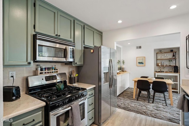 kitchen featuring light countertops, green cabinetry, and stainless steel appliances