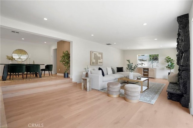 living area featuring recessed lighting, baseboards, visible vents, and light wood finished floors