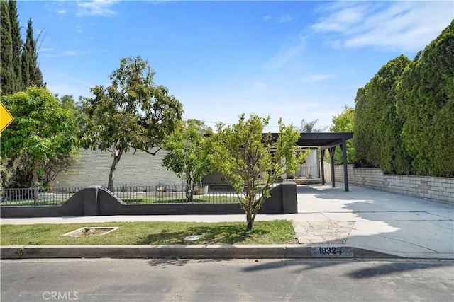 surrounding community with a fenced front yard and concrete driveway