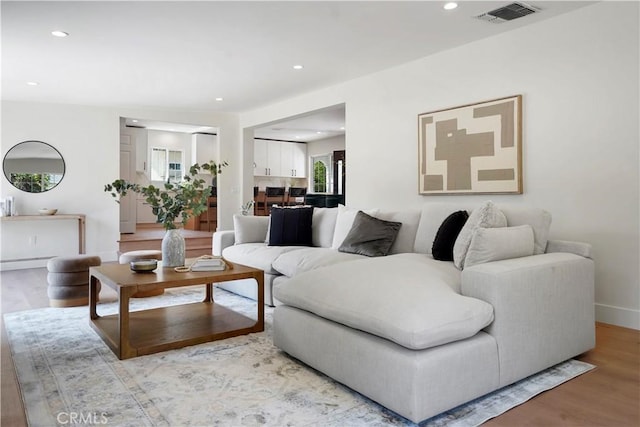 living area featuring visible vents, recessed lighting, baseboards, and wood finished floors