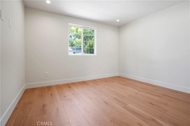 unfurnished room with light wood-style floors, baseboards, and recessed lighting