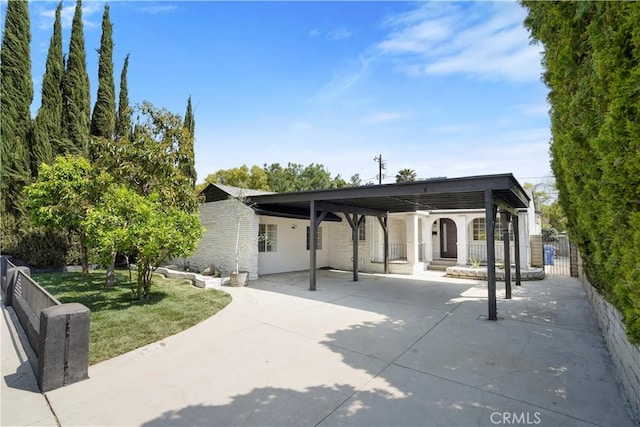 exterior space with a detached carport, fence, and a front yard