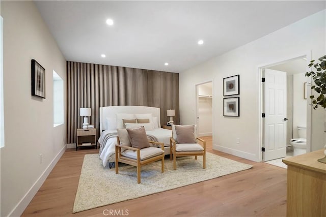 bedroom featuring baseboards, an accent wall, recessed lighting, and light wood-style flooring