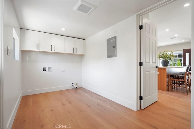 washroom with light wood-style floors, hookup for a washing machine, baseboards, visible vents, and electric panel
