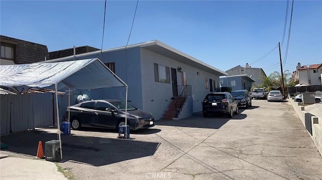 view of side of home with fence and stucco siding