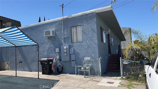 rear view of property with fence and stucco siding