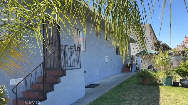 view of side of property with stucco siding and crawl space