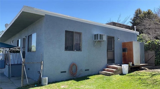 view of property exterior featuring a yard, crawl space, fence, and stucco siding