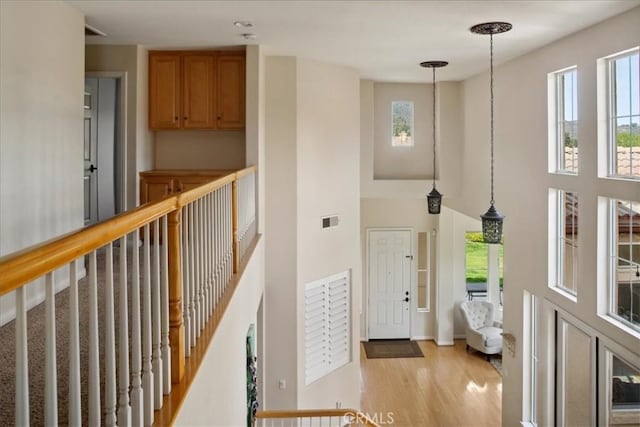 foyer entrance featuring visible vents, light wood finished floors, and a wealth of natural light