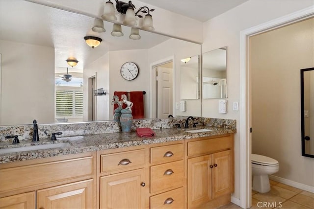 full bathroom with double vanity, a sink, tile patterned floors, and toilet