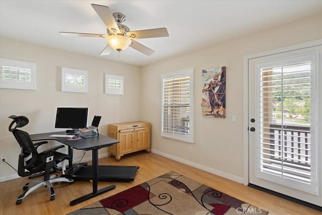 home office featuring baseboards, a ceiling fan, and light wood finished floors
