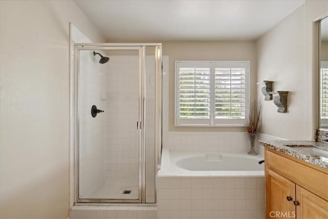 bathroom with vanity, a bath, and a shower stall